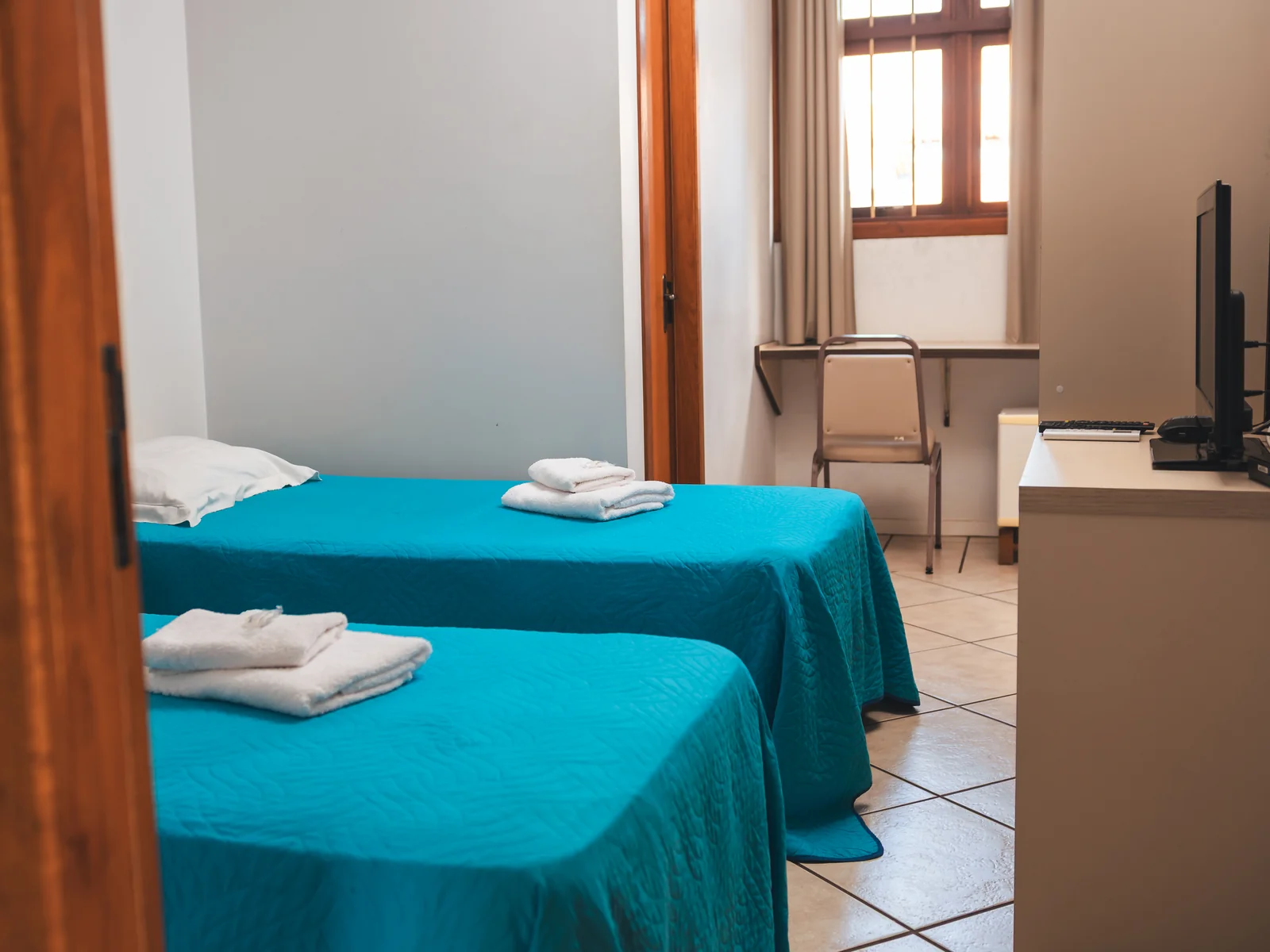 Apartamento Econômico com duas camas de solteiro, TV e mesa de trabalho em São Pedro do Sul