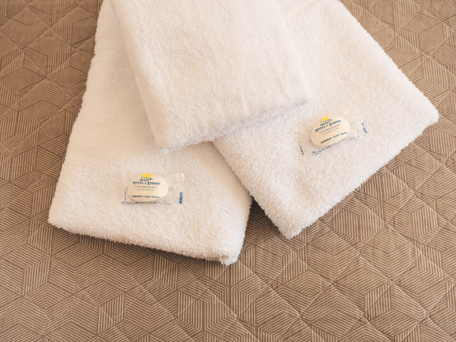 Toalhas e sabonetes do Sítio Hotel & Eventos sobre a cama de Apartamento Superior