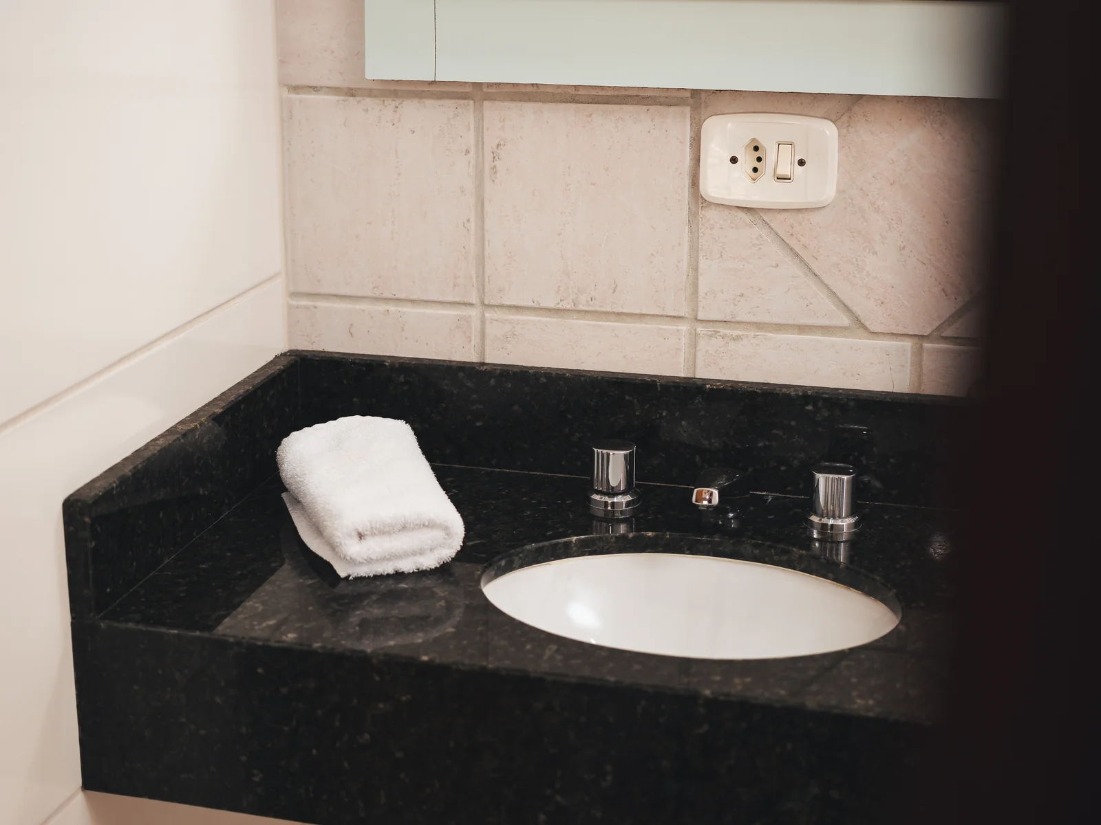 Banheiro de Apartamento Superior com bancada de granito e toalha de rosto