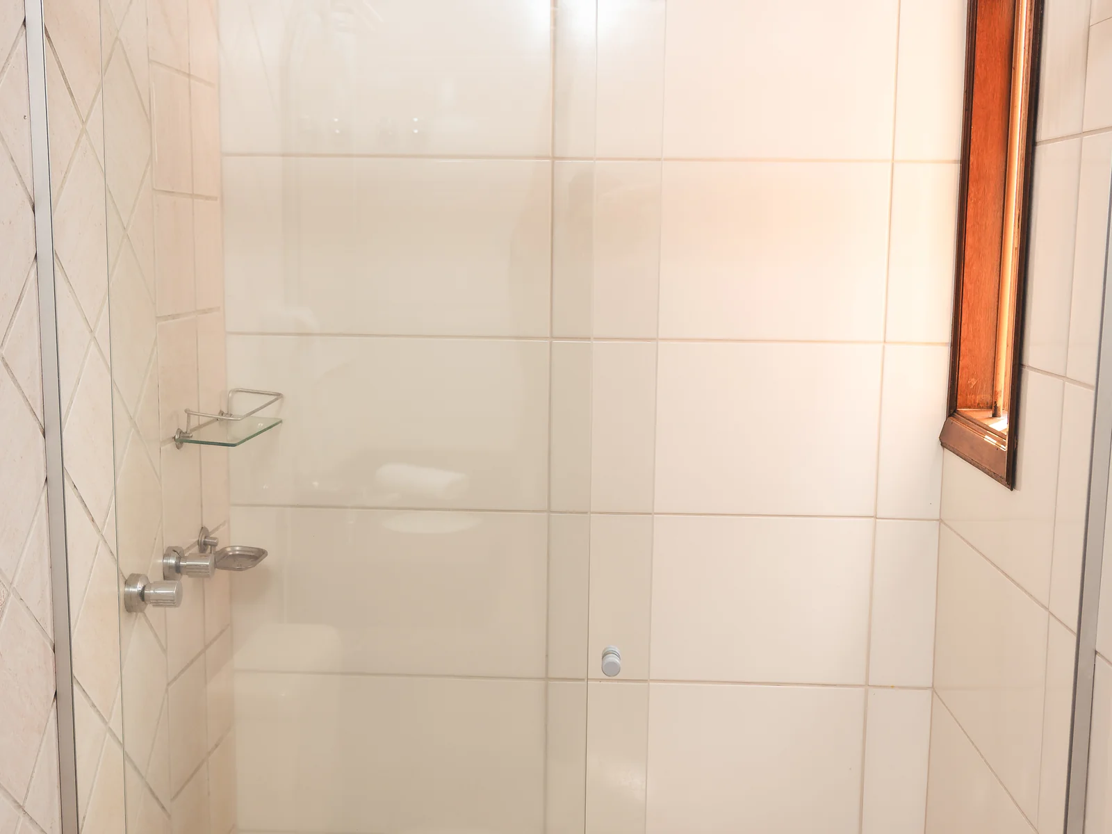 Box de vidro e chuveiro no banheiro de Apartamento Superior do Sítio Hotel & Eventos
